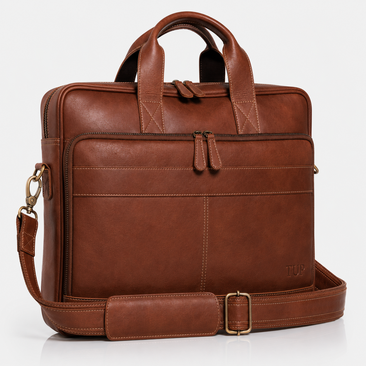 A brown leather briefcase with dual top handles, a front zippered pocket, and an adjustable shoulder strap, photographed on a clean white background.