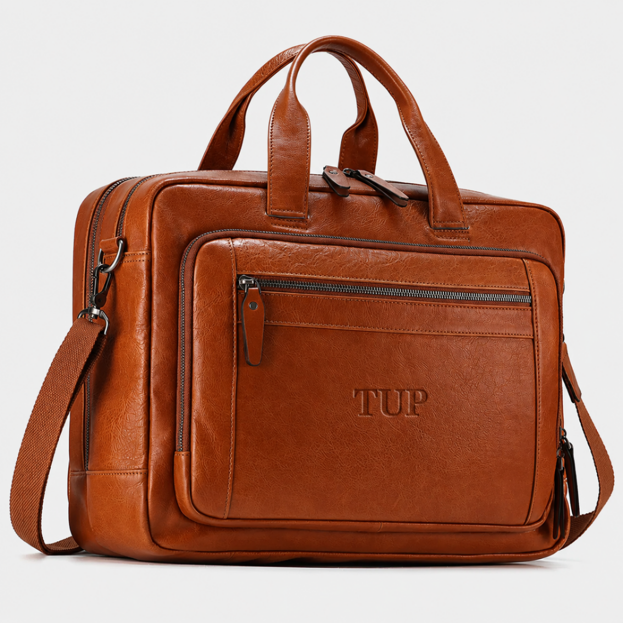 Brown vegetable-tanned full-grain leather messenger bag with front zip pocket, top handles, and adjustable shoulder strap.
