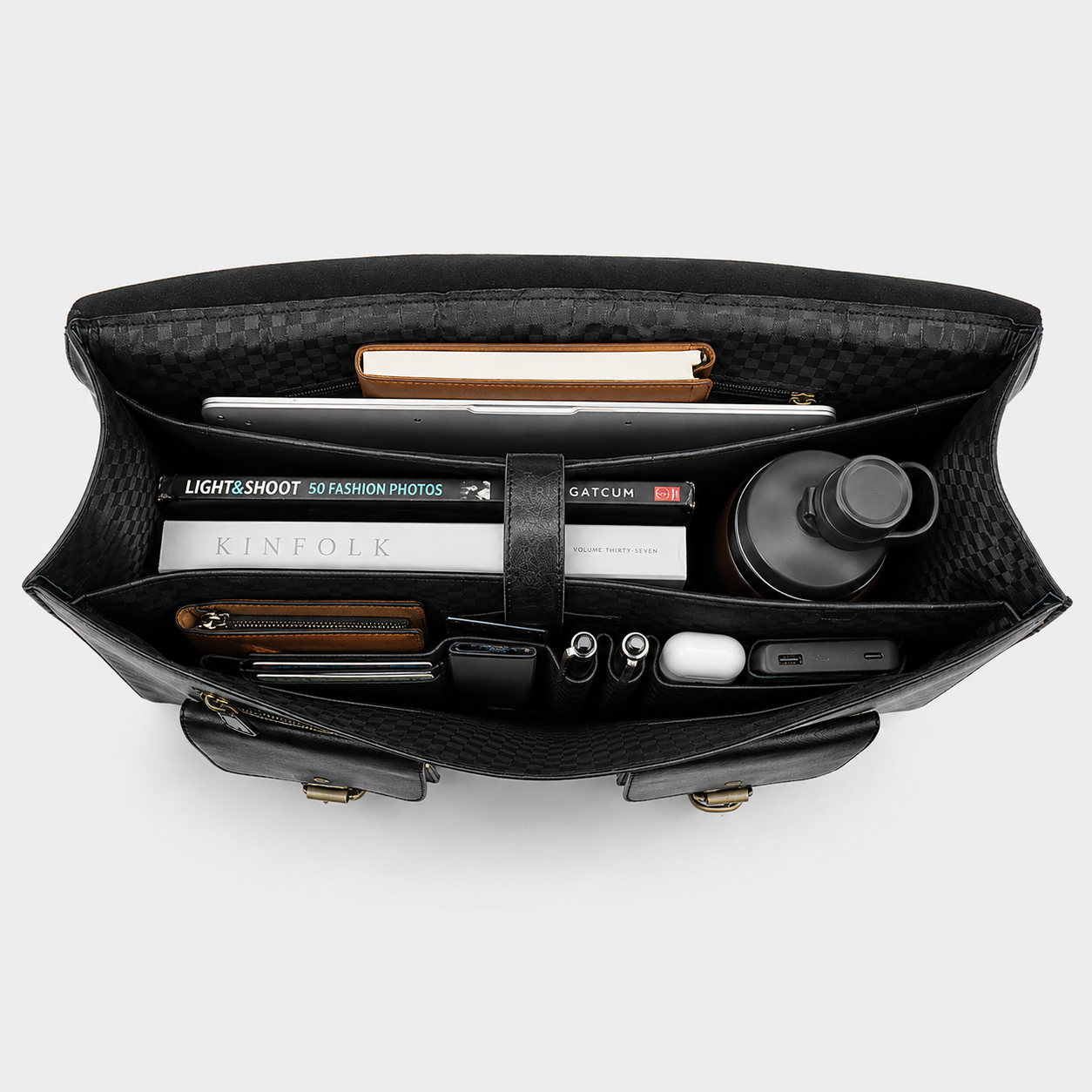 Interior of black leather messenger bag featuring padded laptop sleeve and organized compartments.