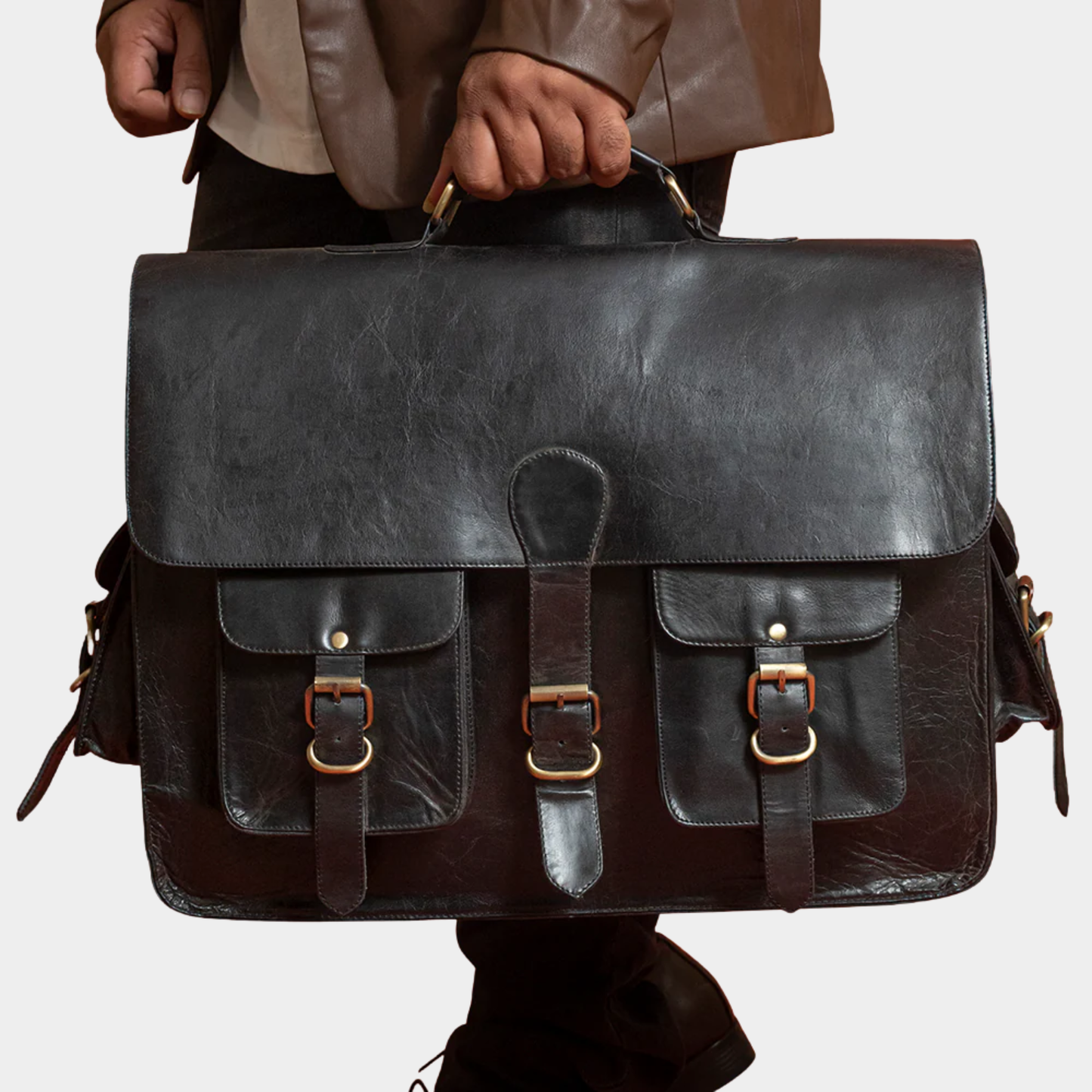 Black leather messenger bag worn by a professional for office and business travel.