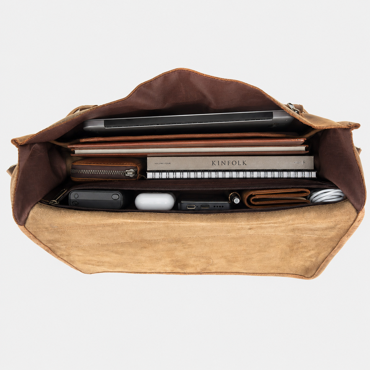 Interior of leather messenger bag featuring padded laptop compartment, organizer pockets, and spacious storage.