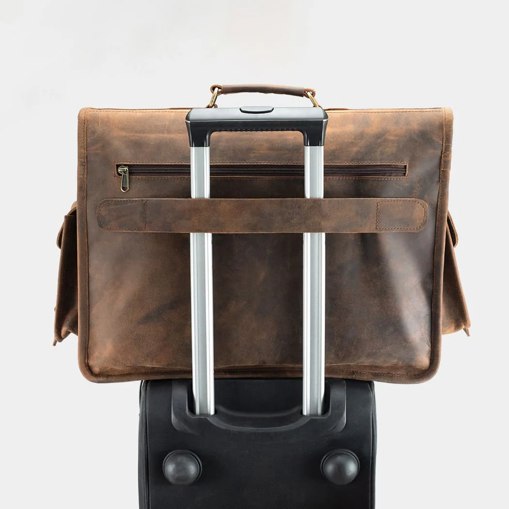 Leather messenger bag attached to rolling luggage for convenient business travel.