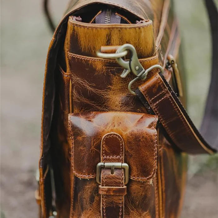 Close-up of premium full-grain leather and brass hardware on the Norwood messenger bag.