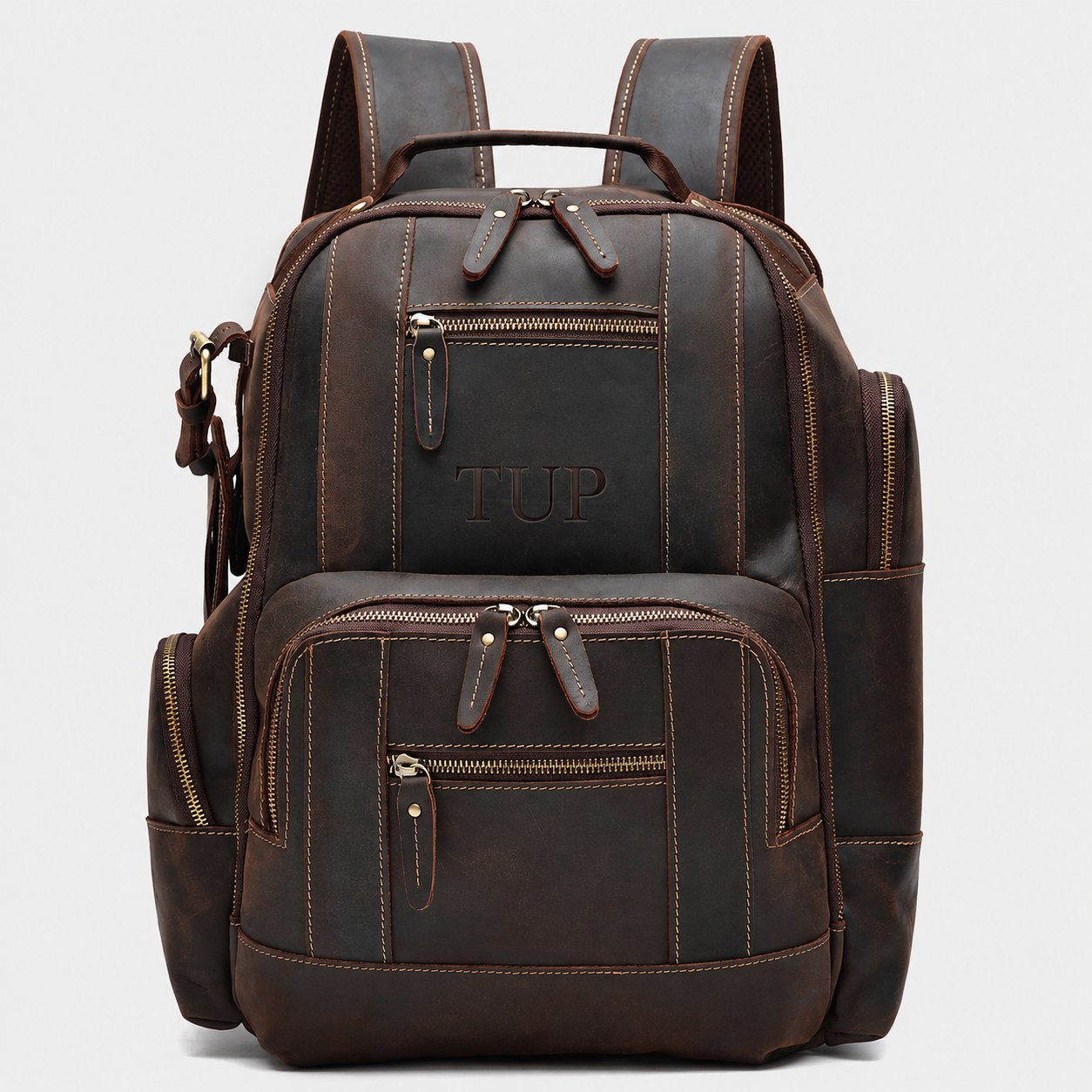 The Atlas full grain leather backpack in dark brown with multiple front organizer pockets and premium brass hardware