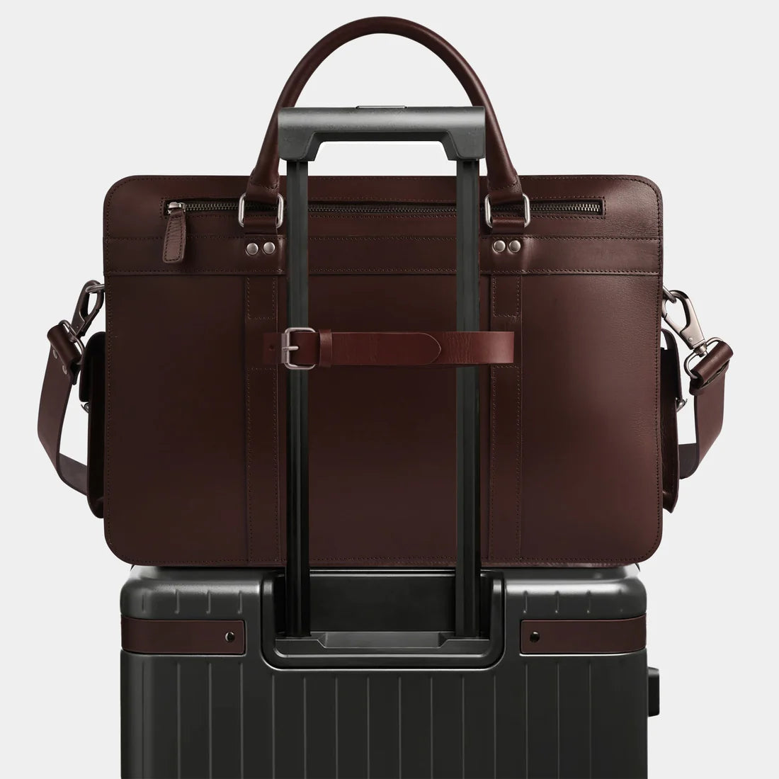 Leather work bag attached to rolling luggage using rear luggage strap