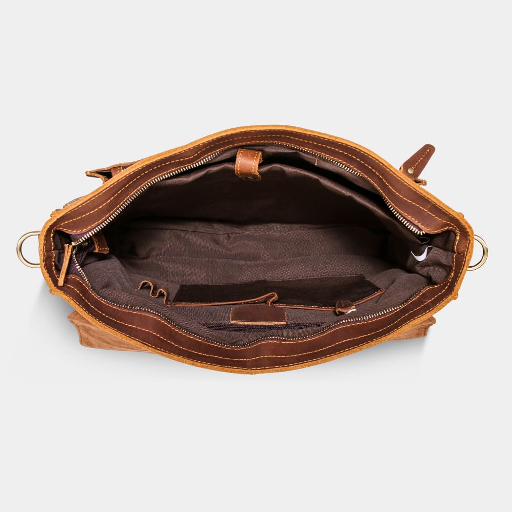 Brown leather bag with open interior on a light gray background
