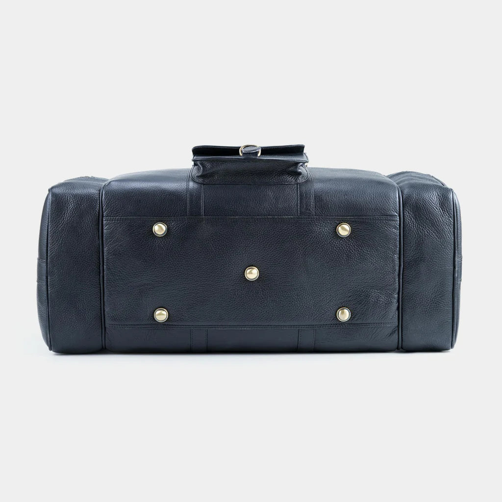 Side view of black leather weekender bag with brass feet