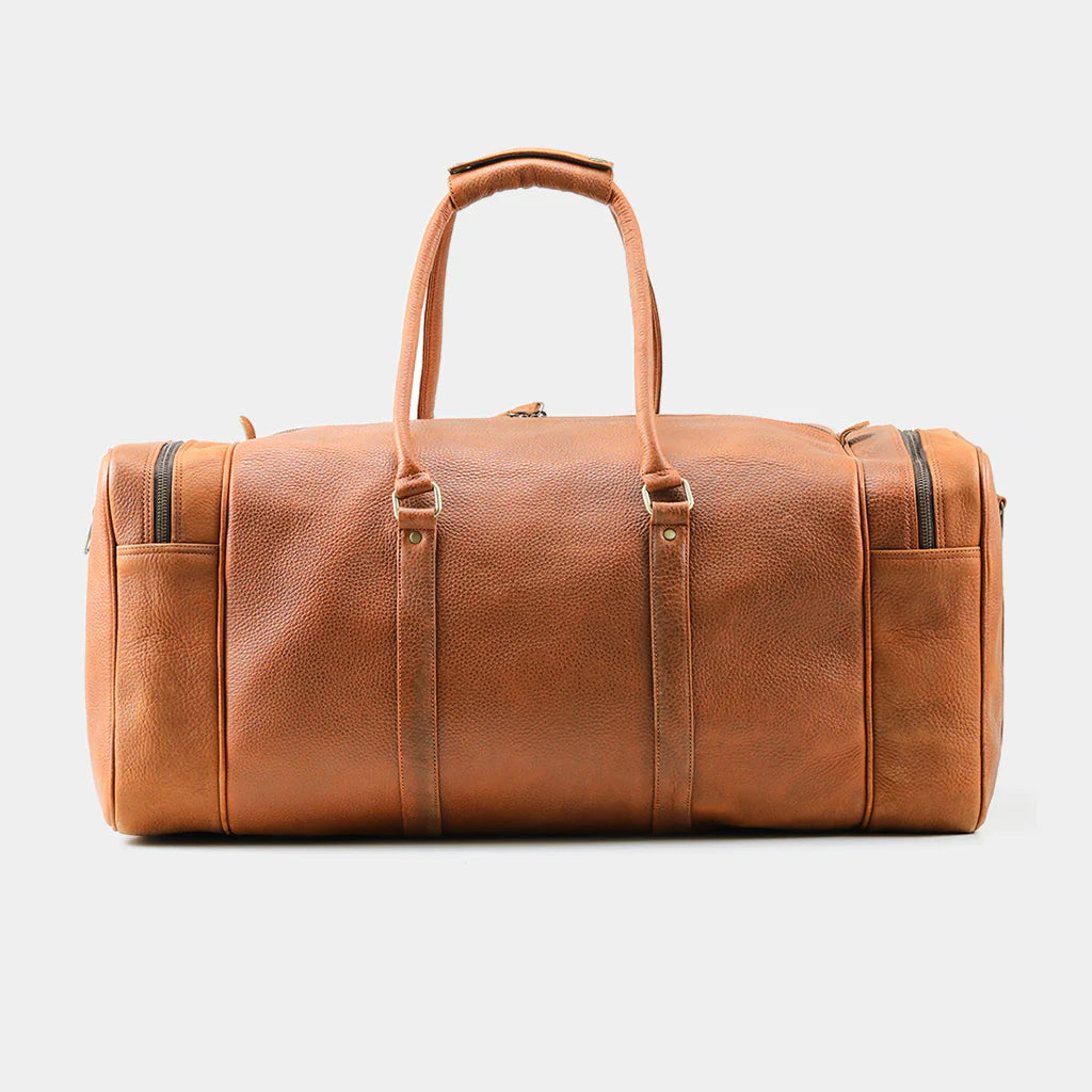 Side profile of handcrafted tan leather duffle bag with premium brass hardware