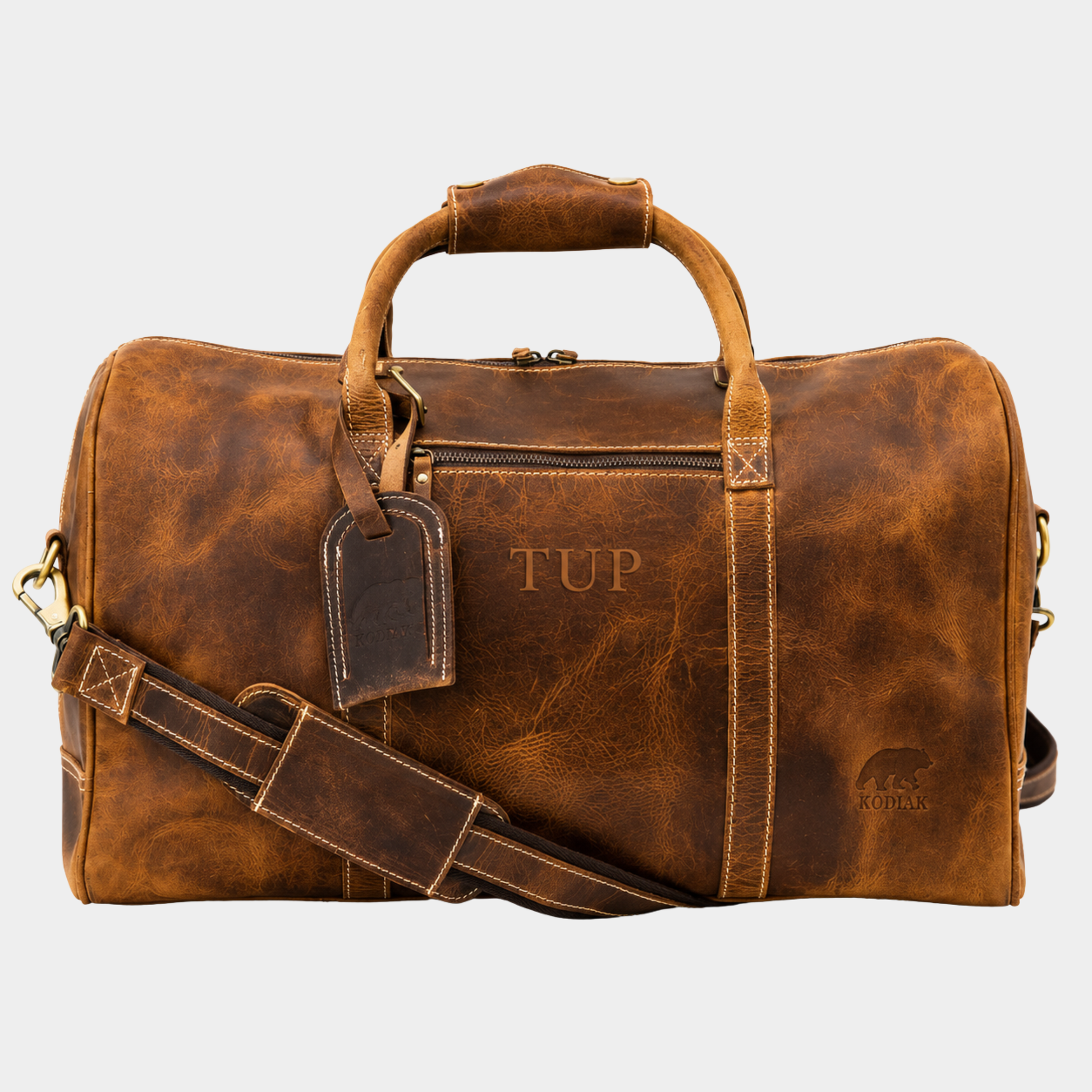 The Overnighter 30L top grain leather duffle bag in vintage brown with adjustable shoulder strap and luggage tag