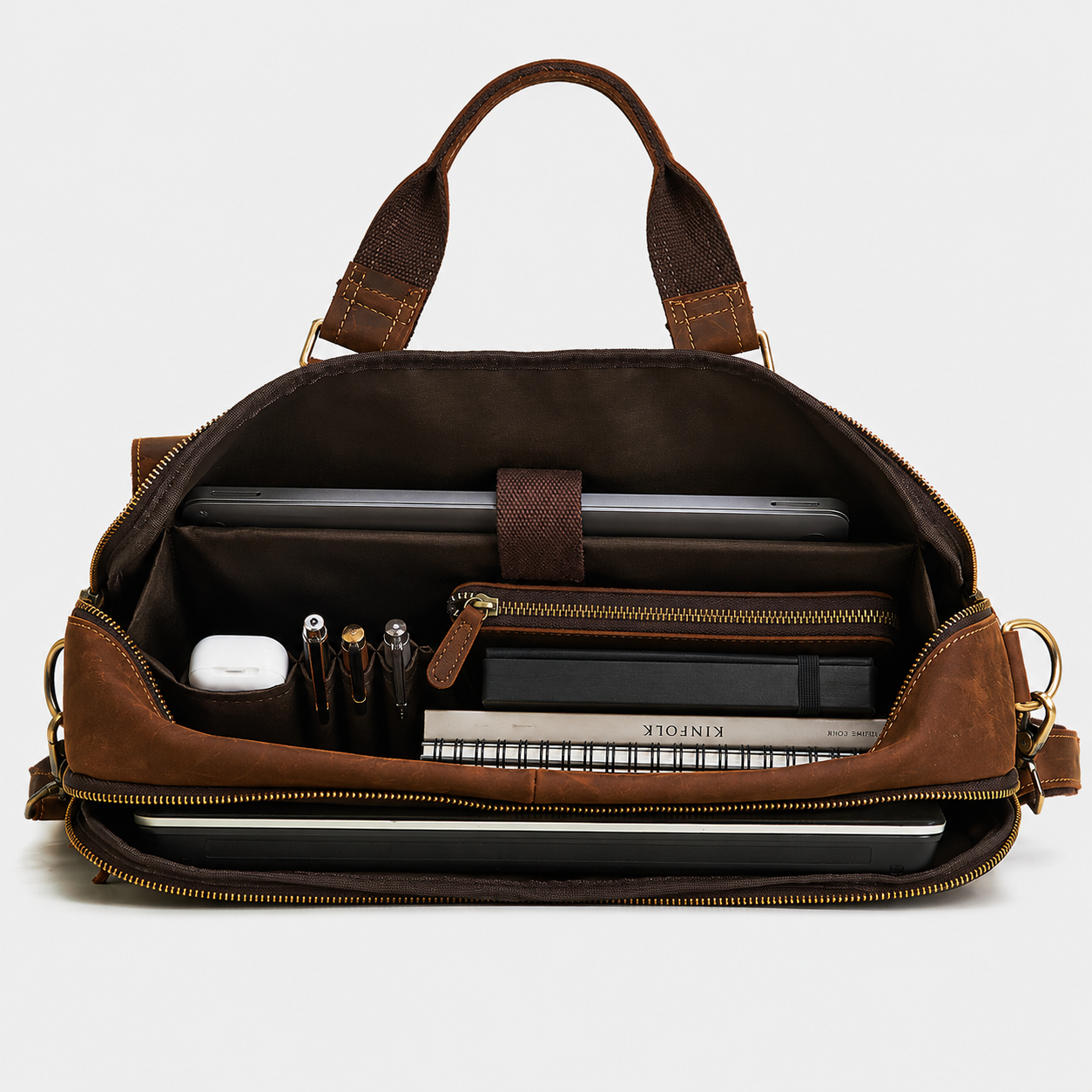 Interior of leather messenger bag featuring padded laptop compartment and organized storage pockets for work essentials.