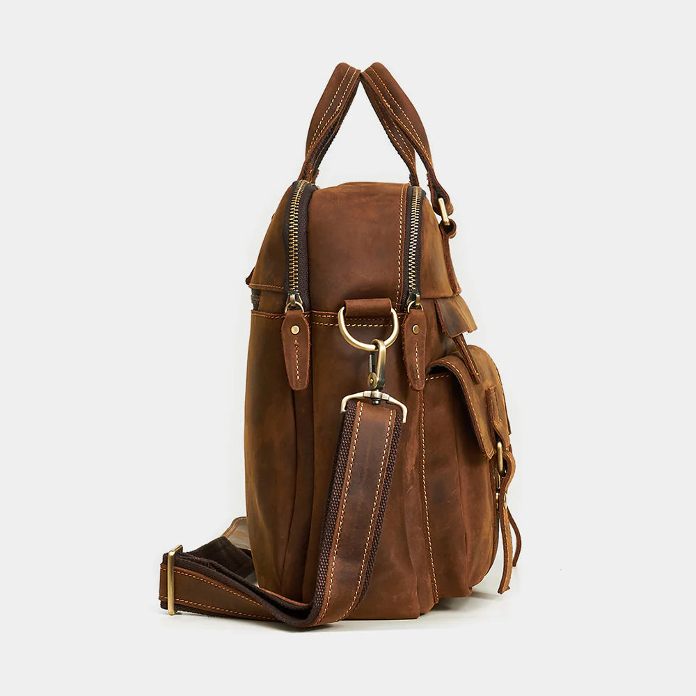 Side profile of leather messenger bag showing slim design and adjustable shoulder strap.